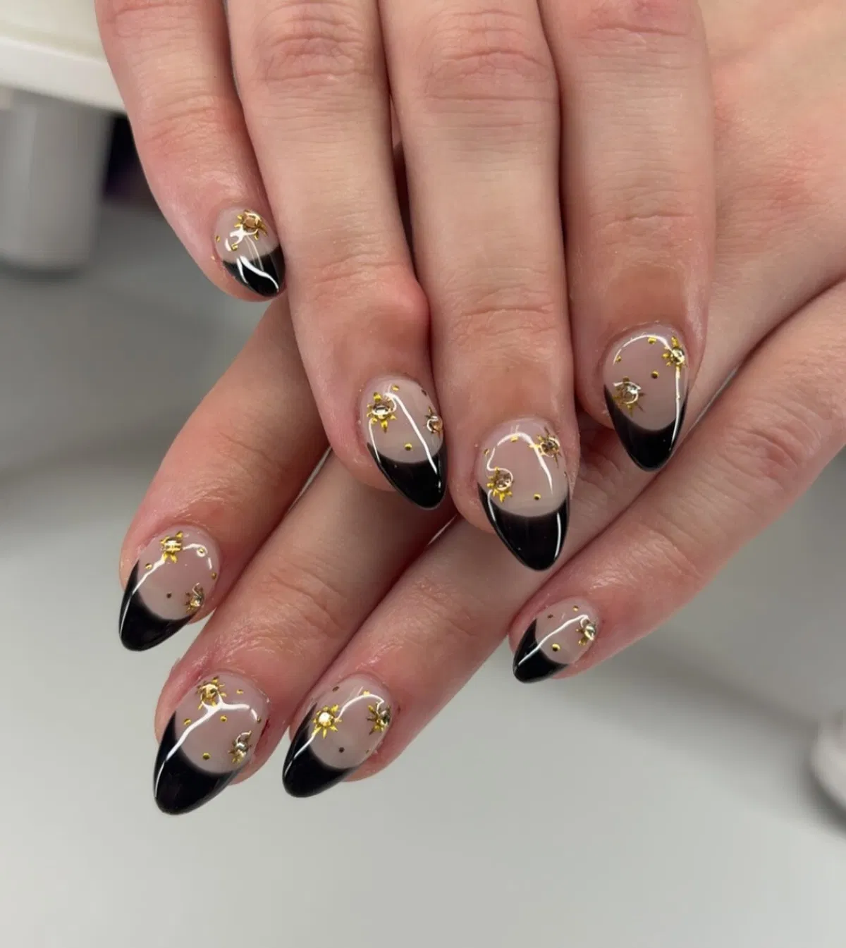 Black French tips with gold star studs and dots