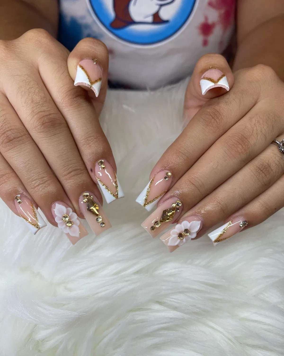 V-French white tips with gold glitter lines and floral statement accents