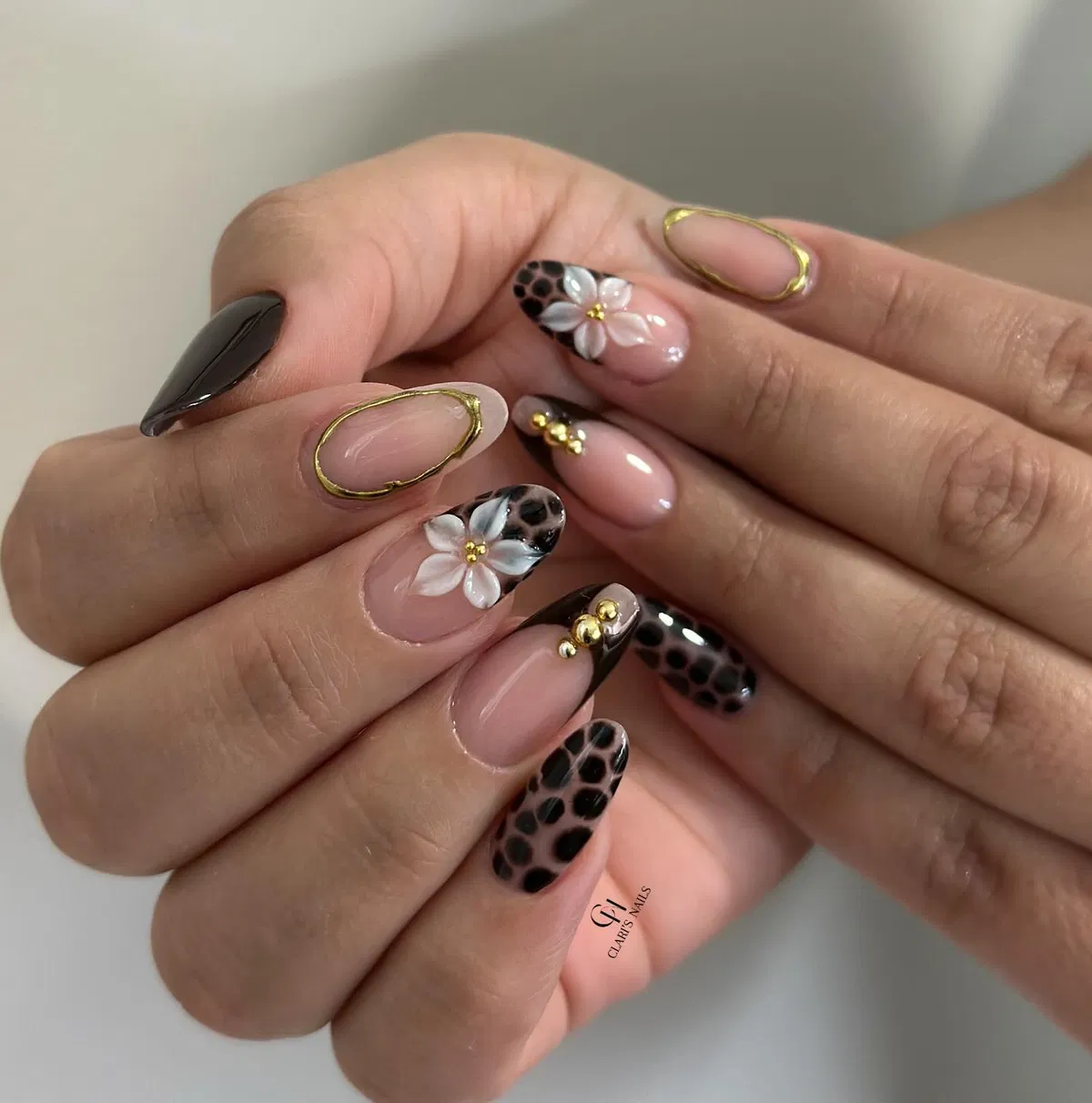 Black-tipped nude almonds with gold frames and raised white flowers