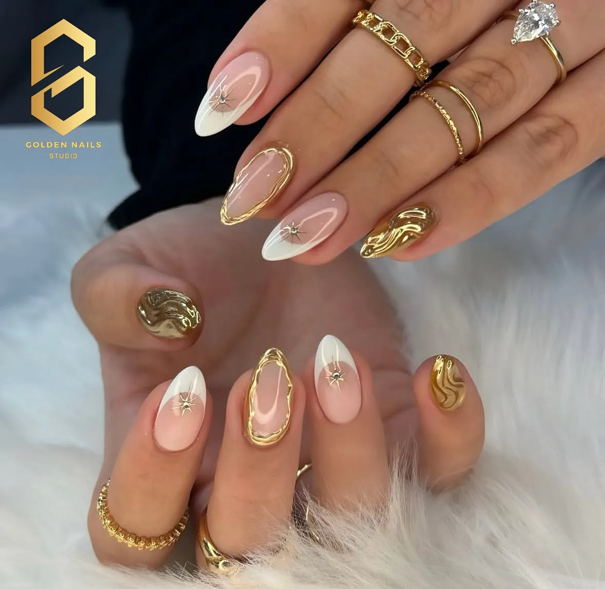 Gold-framed nude nails with white tips and sculpted gold accents