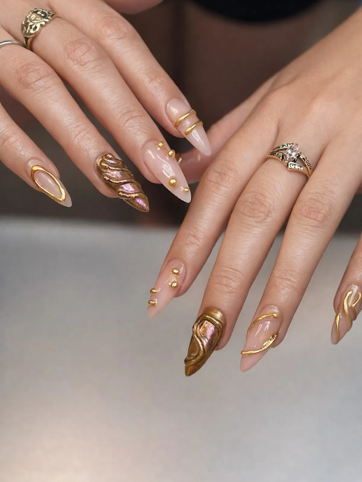Gold-framed nude stilettos with iridescent sculpted accent