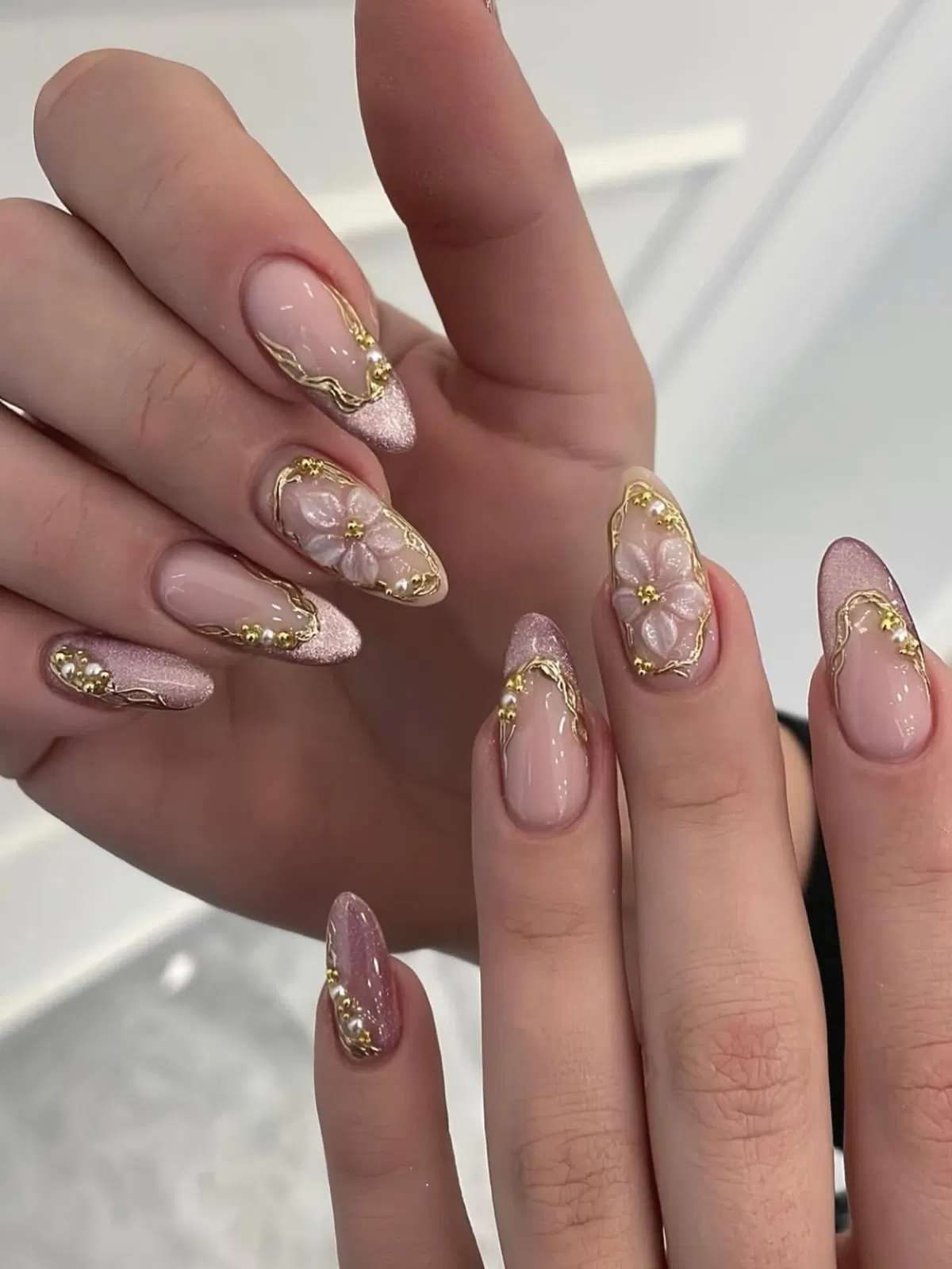 Pink shimmer tips with gold edging and raised floral accents