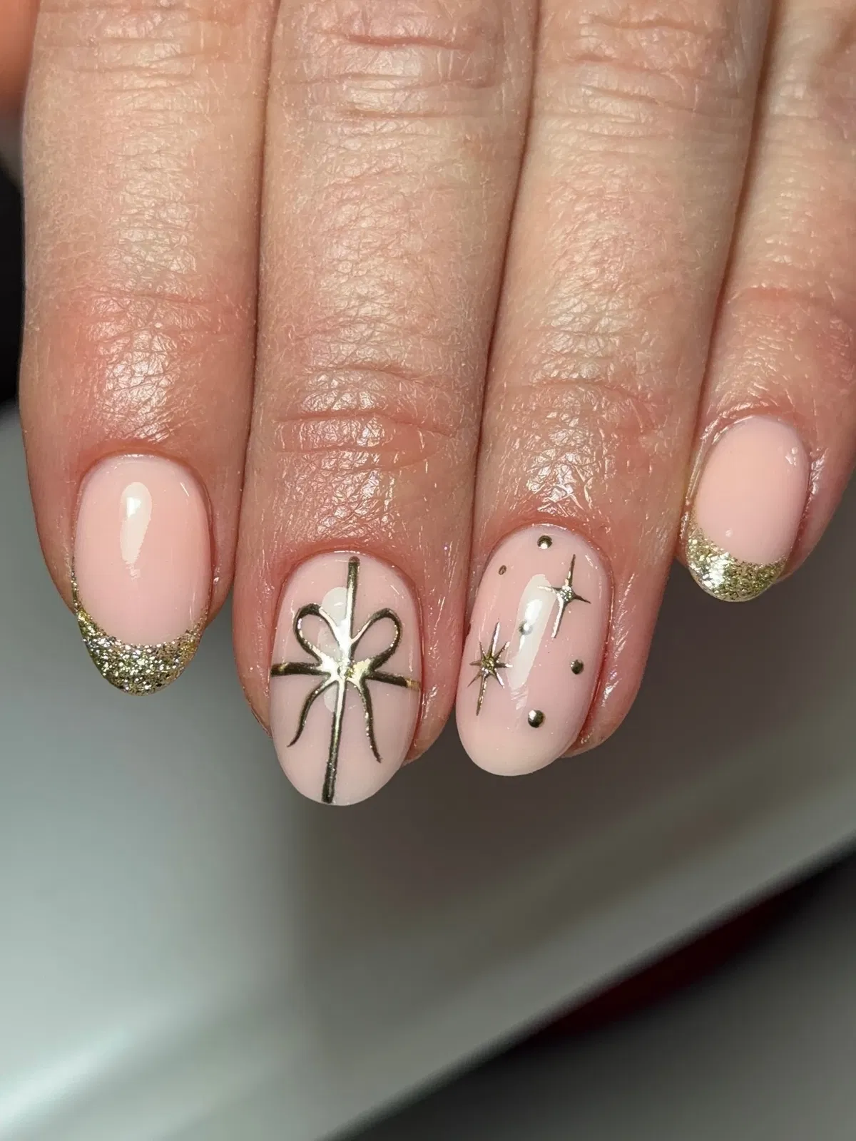 Pale Pink Short Nails with Gold Glitter Tips and Star Details