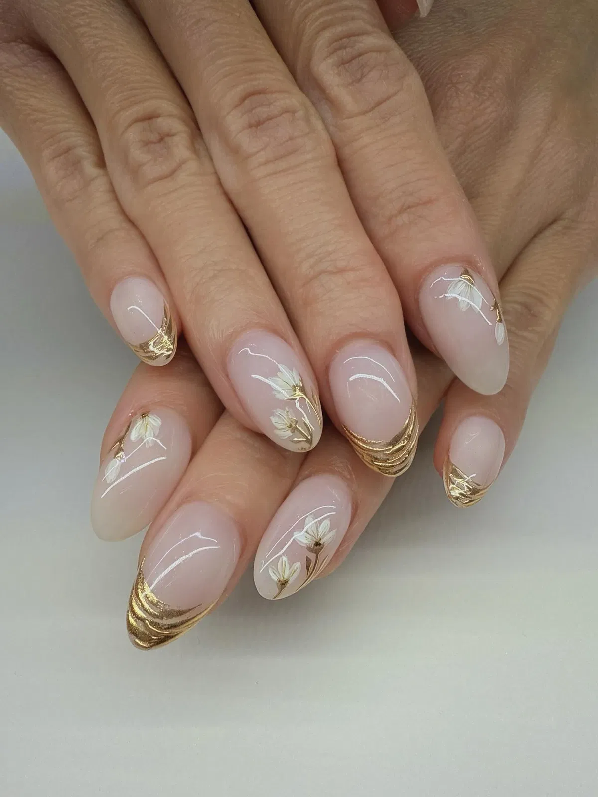 Layered gold French tips with delicate white floral art