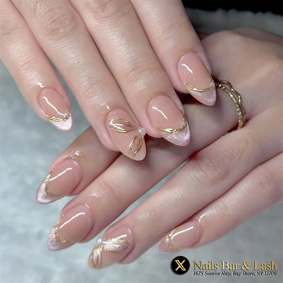 Soft glitter French tips with thin gold lines and a pearl accent