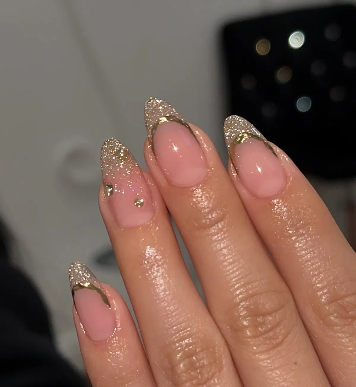 Pink almond nails with gold glitter French tips and gold outline