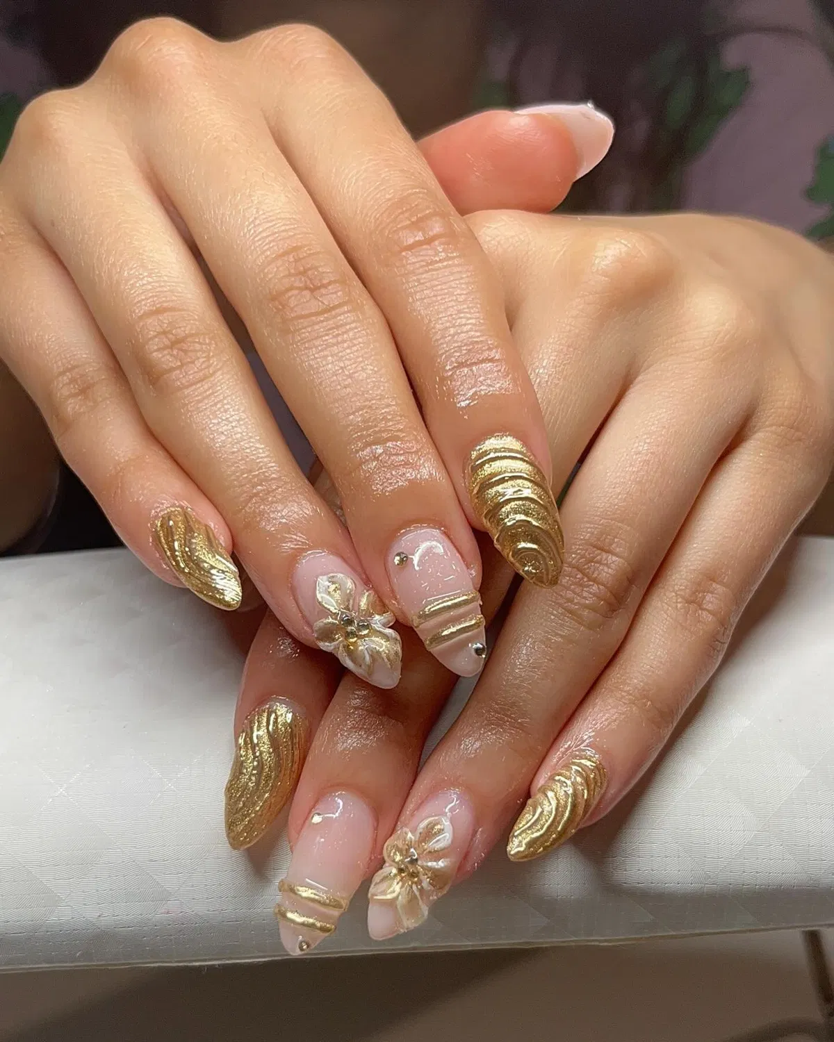 Textured full-gold nails with 3D floral accents