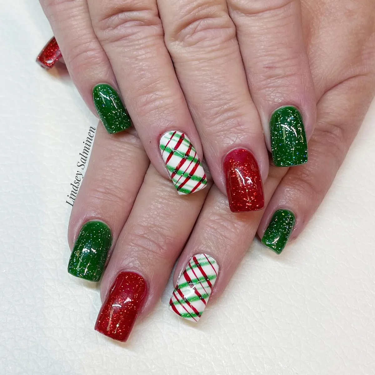 Glittery red-and-green mix with diagonal plaid accent nails