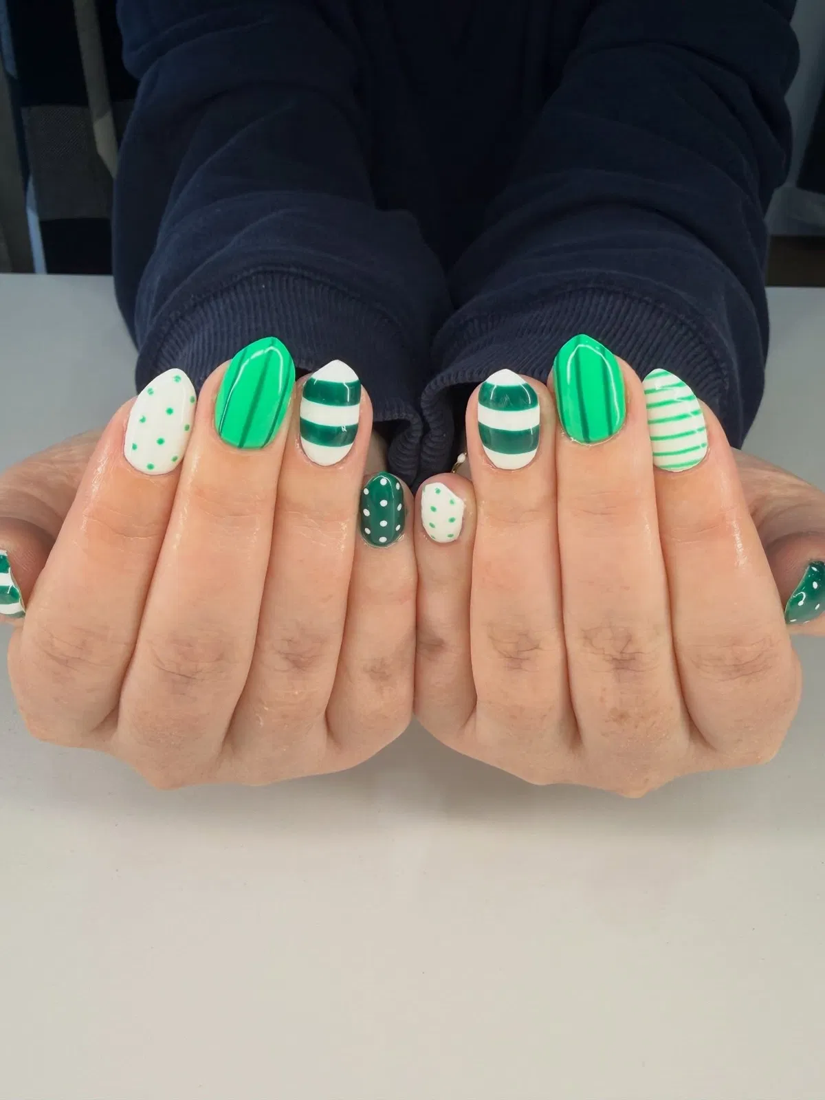 Green stripes and polka dots with bold banded accents (no plaid visible)