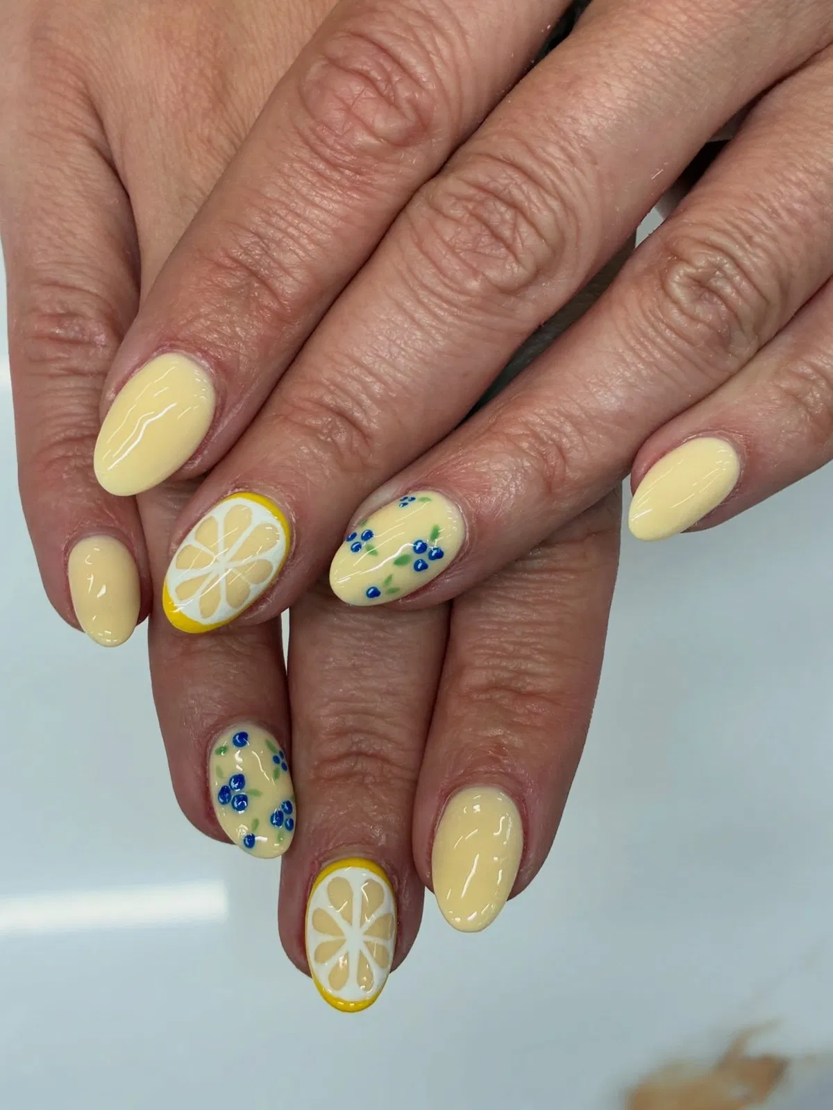 Pale Yellow Almond Nails with Lemon Slice and Blue Florals