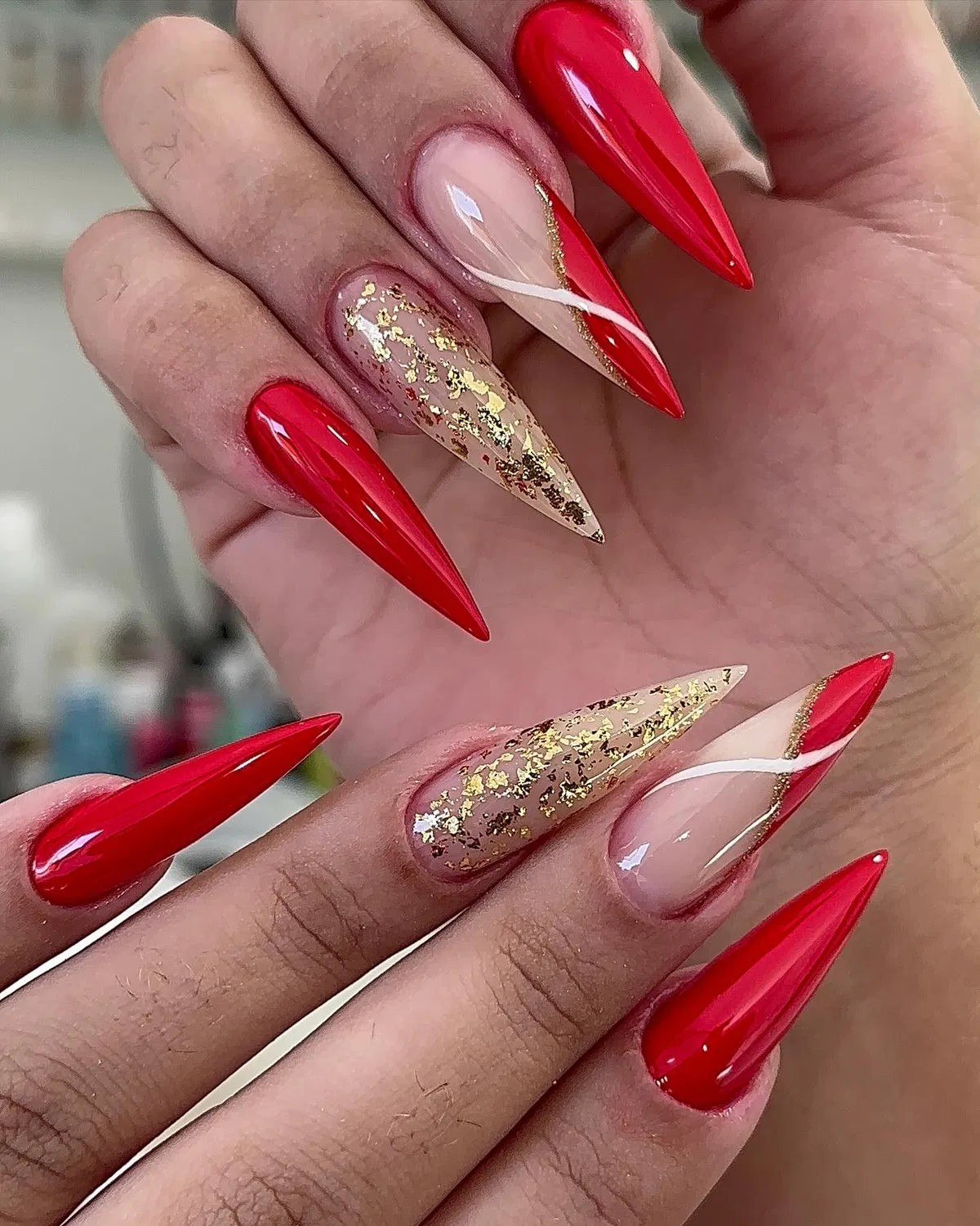 Bright red stilettos with gold flake accents and diagonal red tips