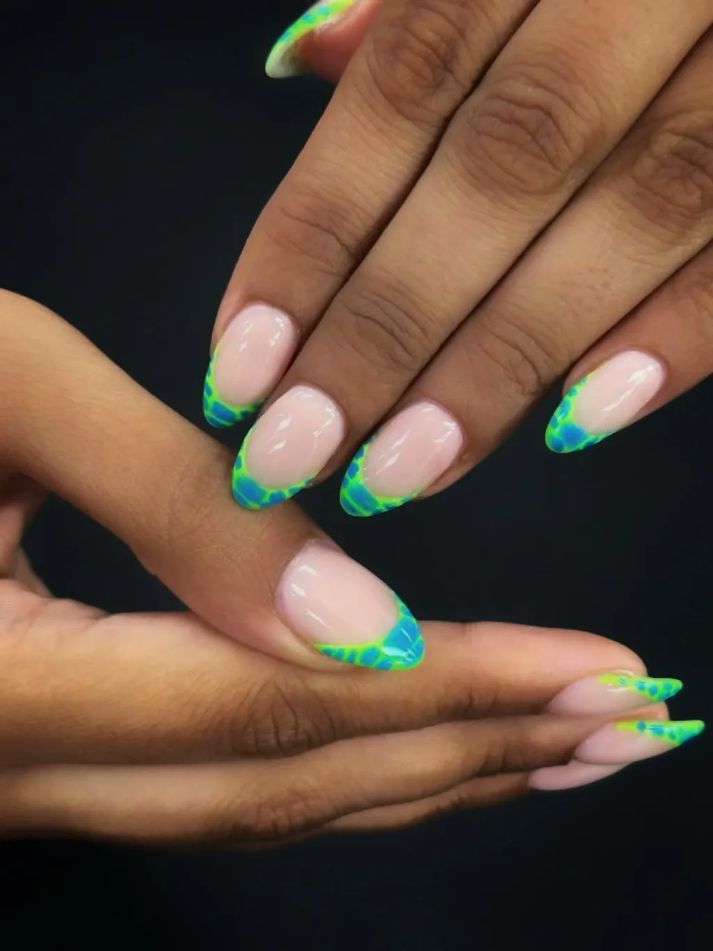 Nude almond nails with blue and neon green patterned tips