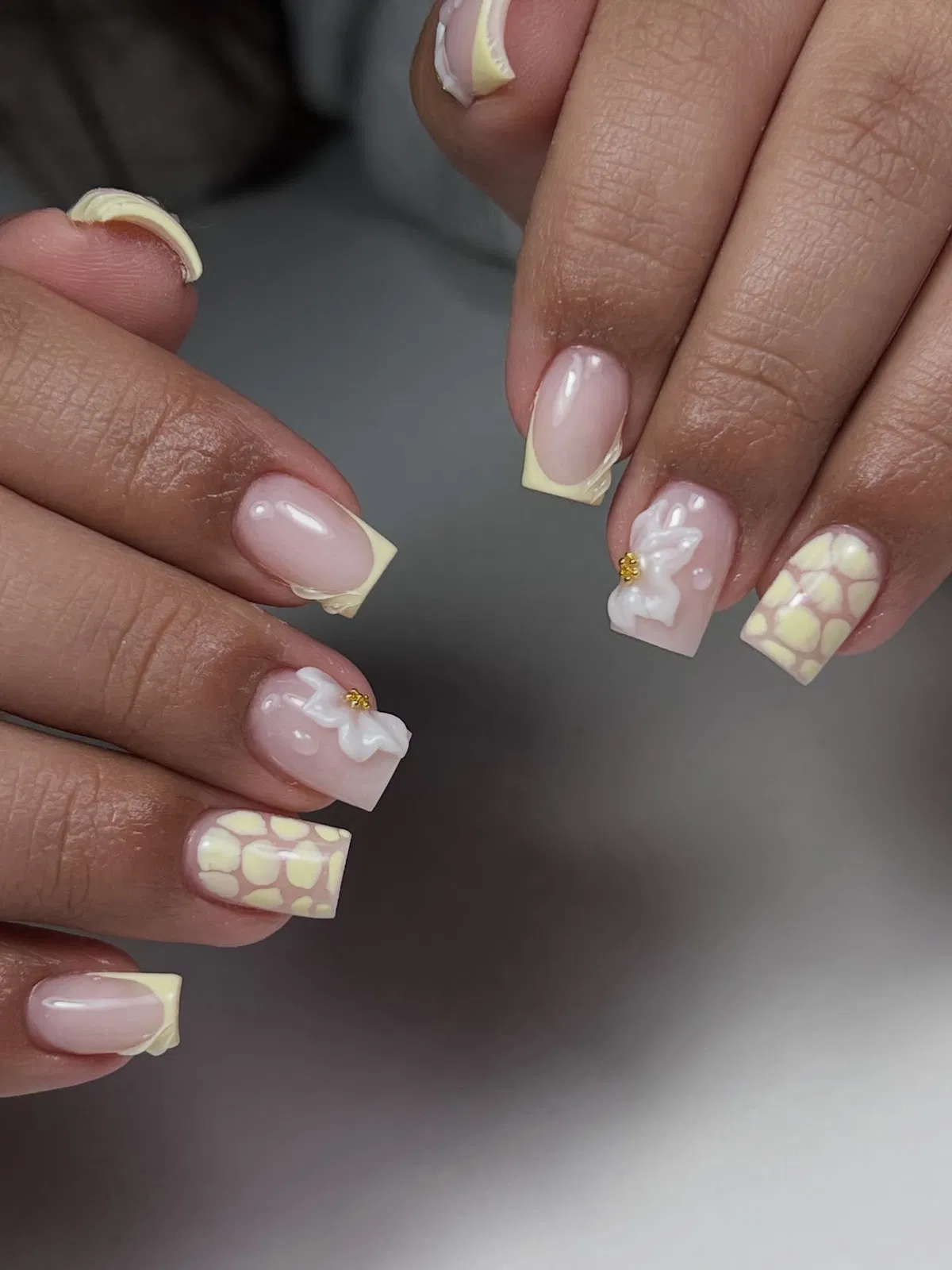 Pale yellow French tips with 3D flowers and spotted accents