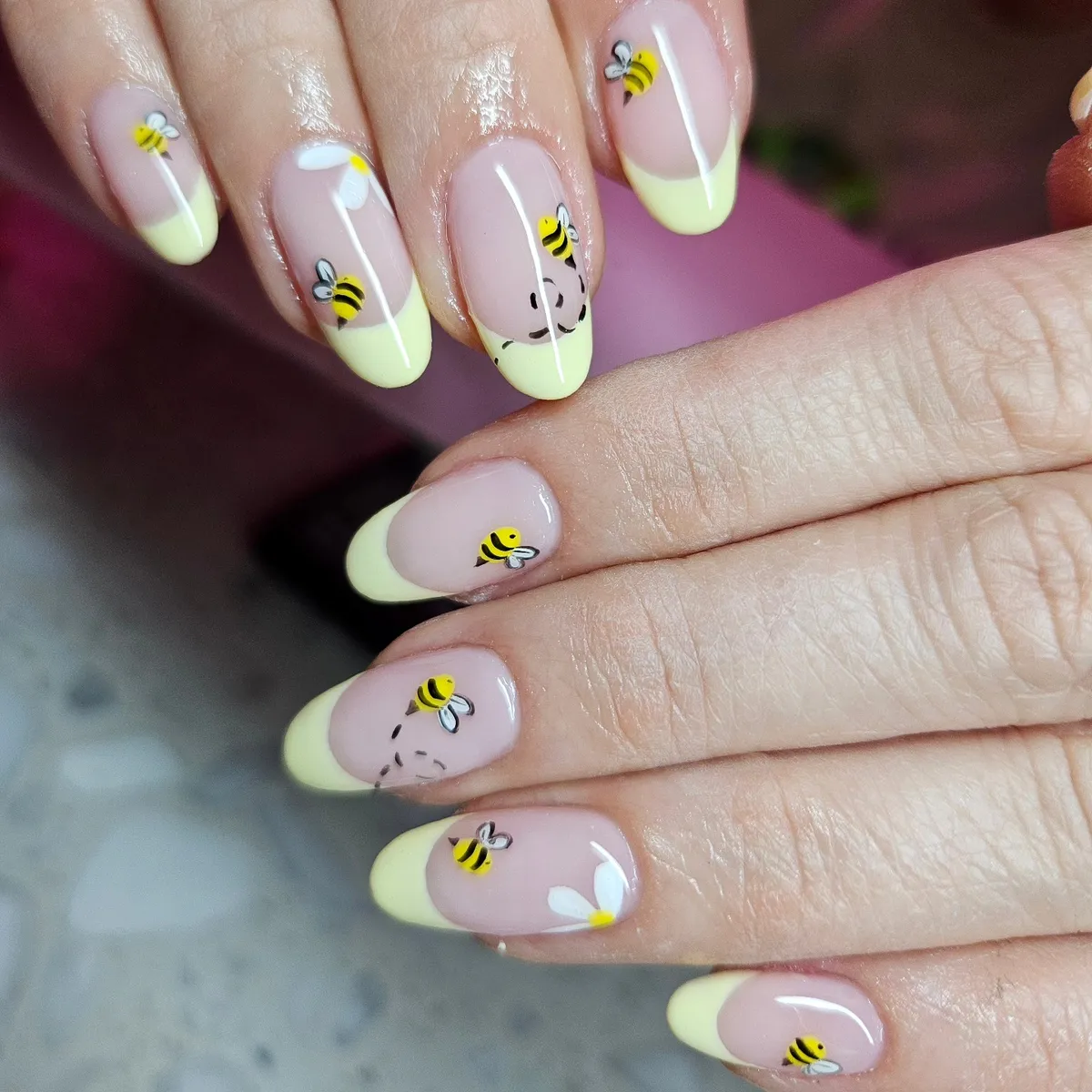 Pastel yellow French tips with bees and white flowers