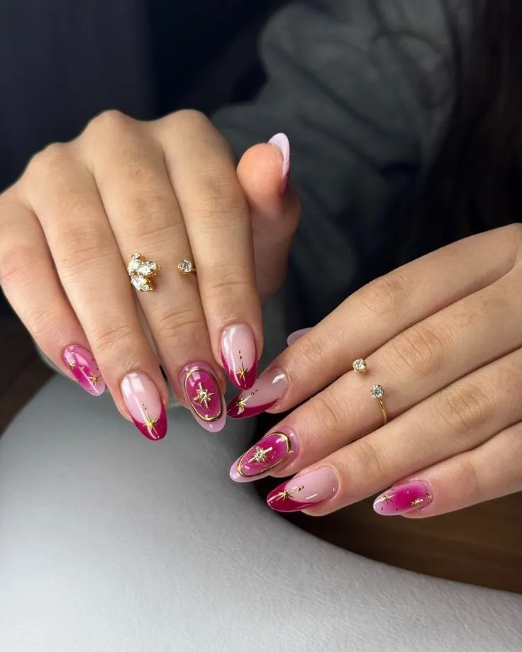 Gold starbursts and oval frames on pink gradient nails