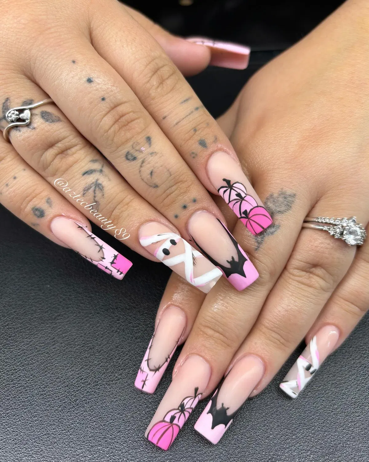Nude base with bright pink tips and black spooky-style silhouettes