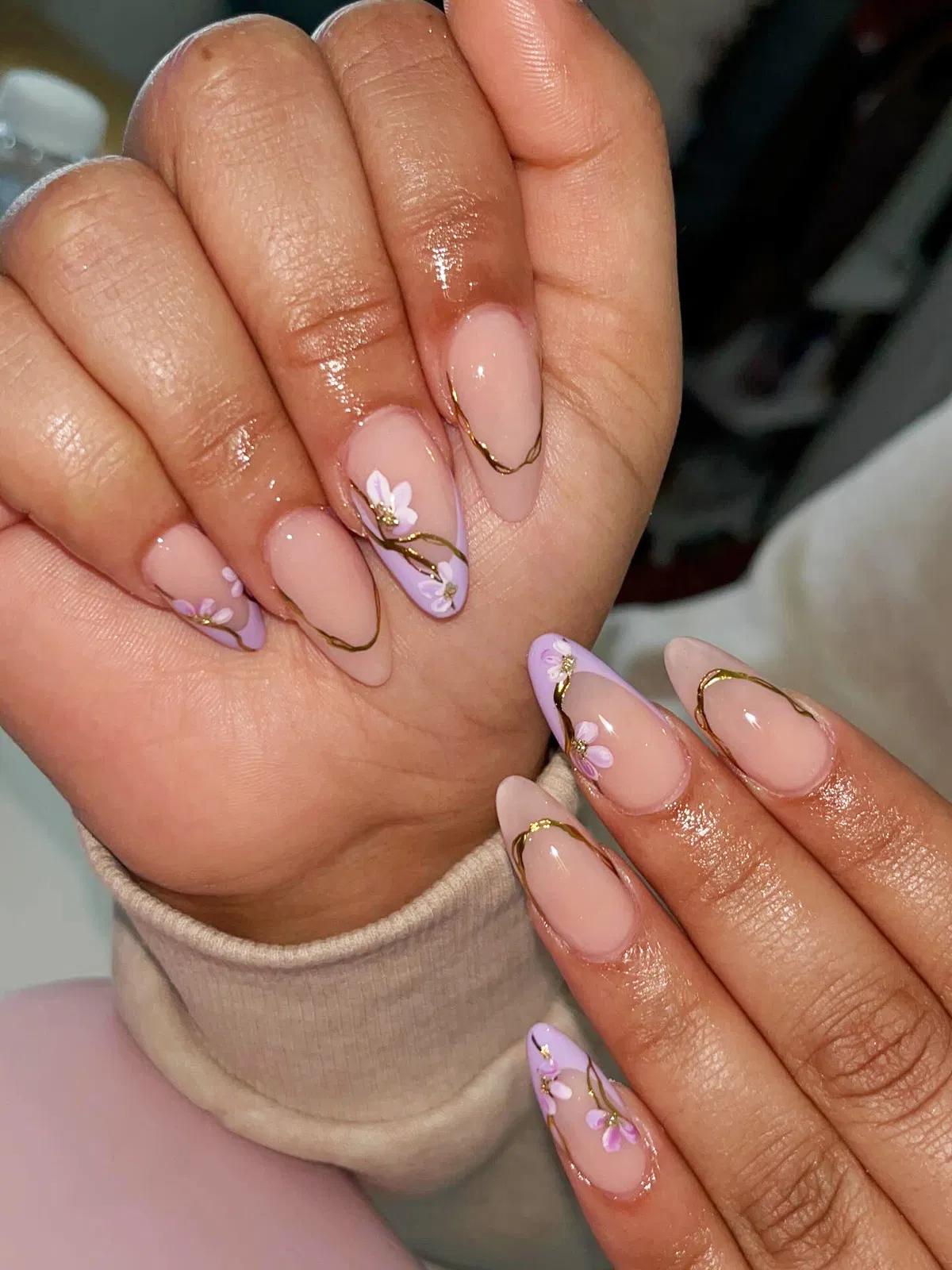 Minimal nude nails with lavender flowers and thin gold waves