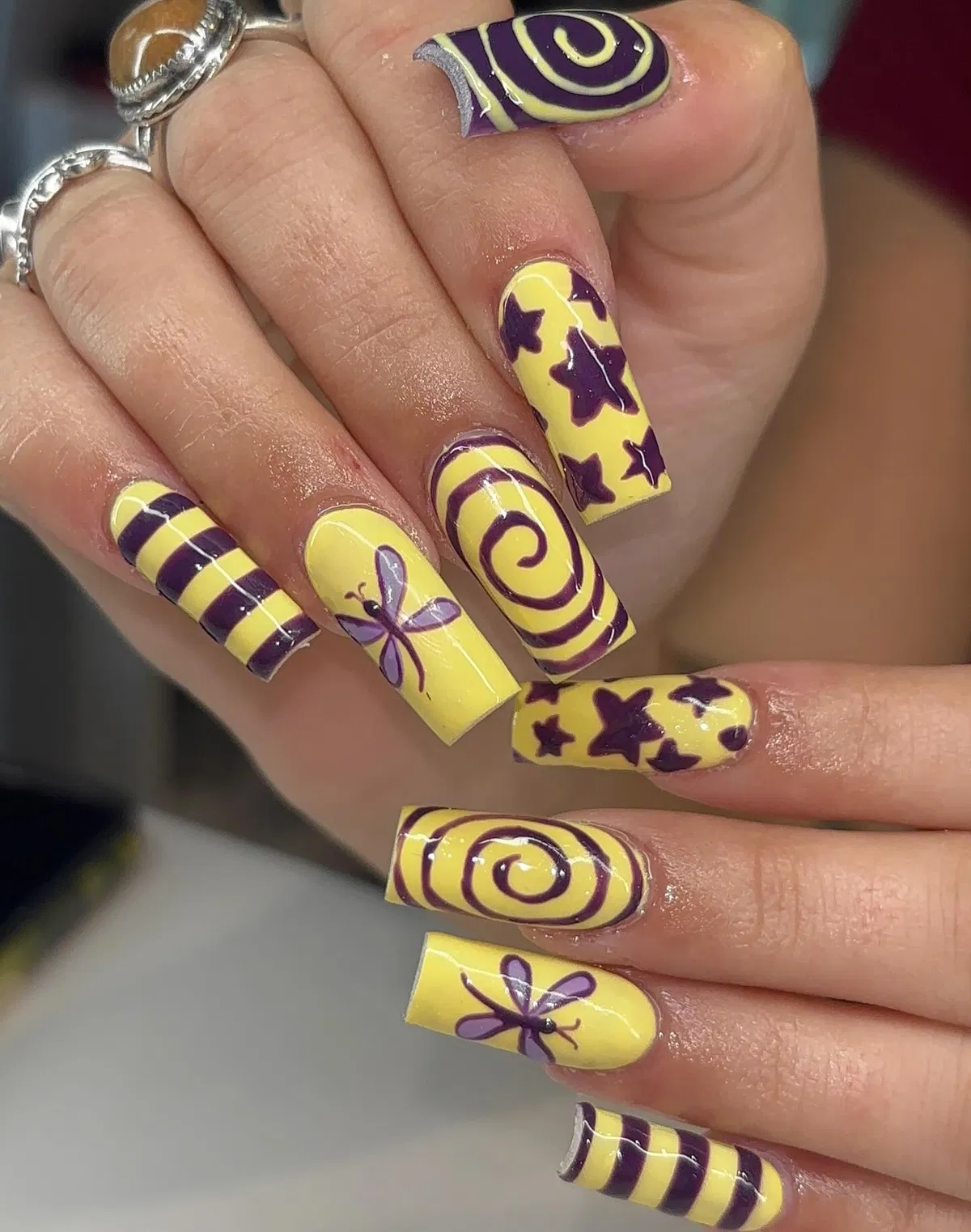 Bold yellow base with purple stars, spirals, and stripes