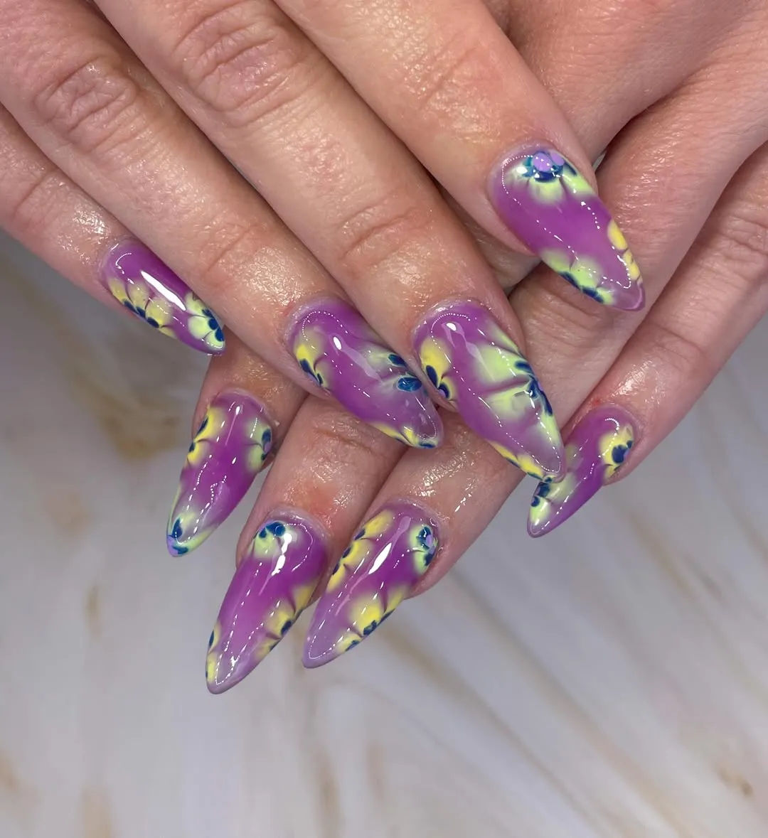 Abstract purple nails with yellow and blue swirls