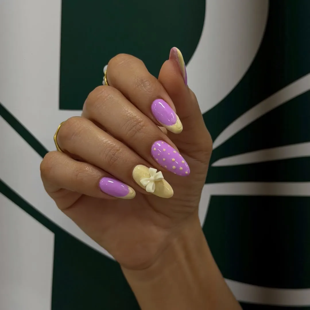 Purple French tips with pale yellow and a white bow accent
