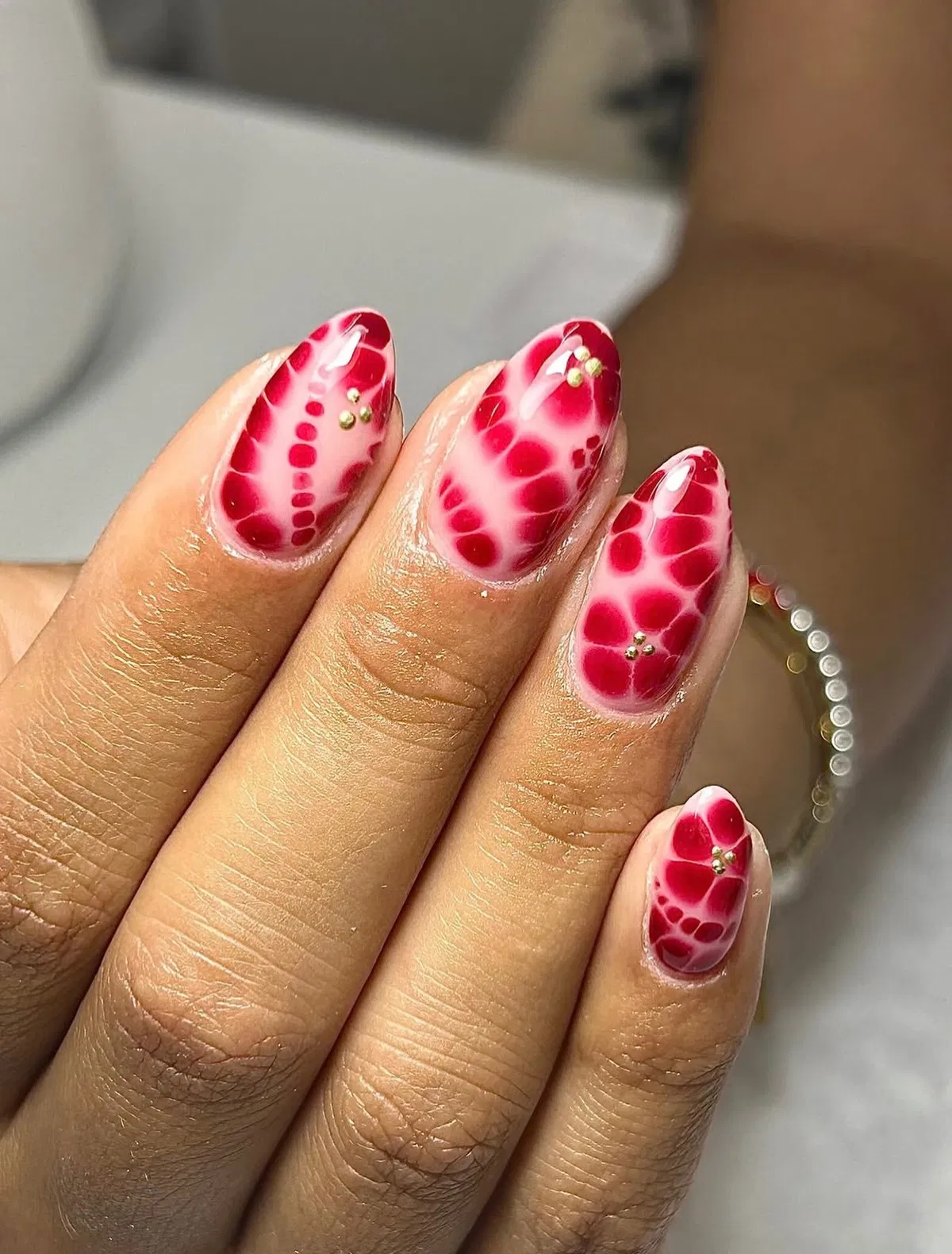 Red cellular aura pattern with gold stud accents