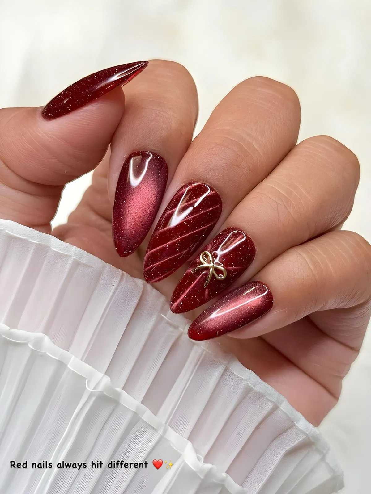 Glittery deep red set with a small gold bow charm