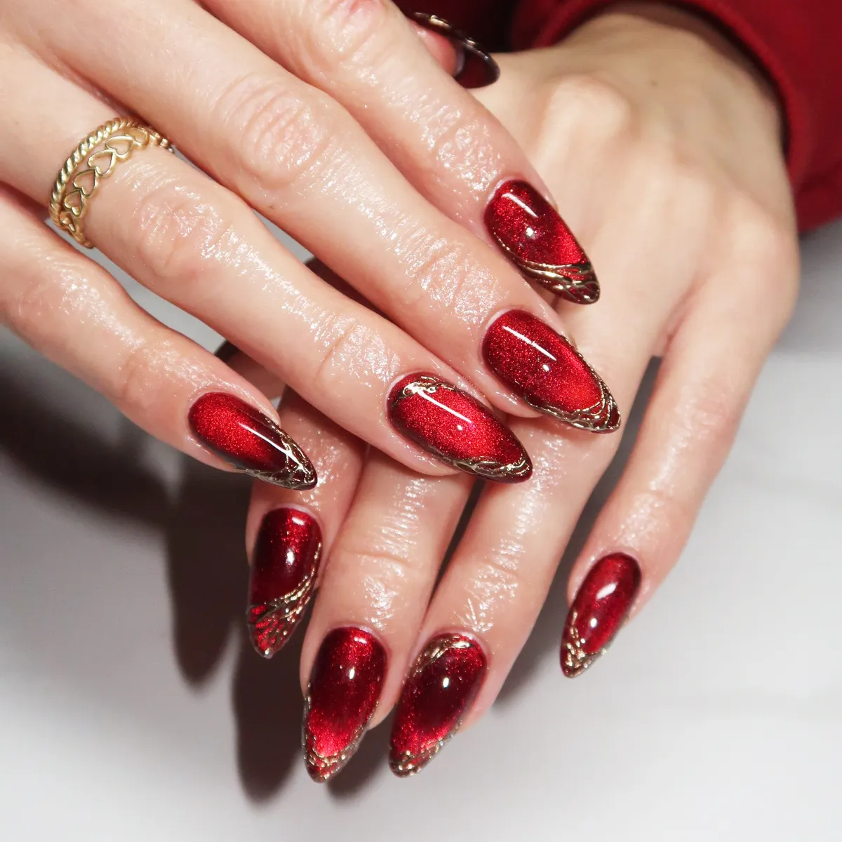 Red shimmer nails with gold tip detailing