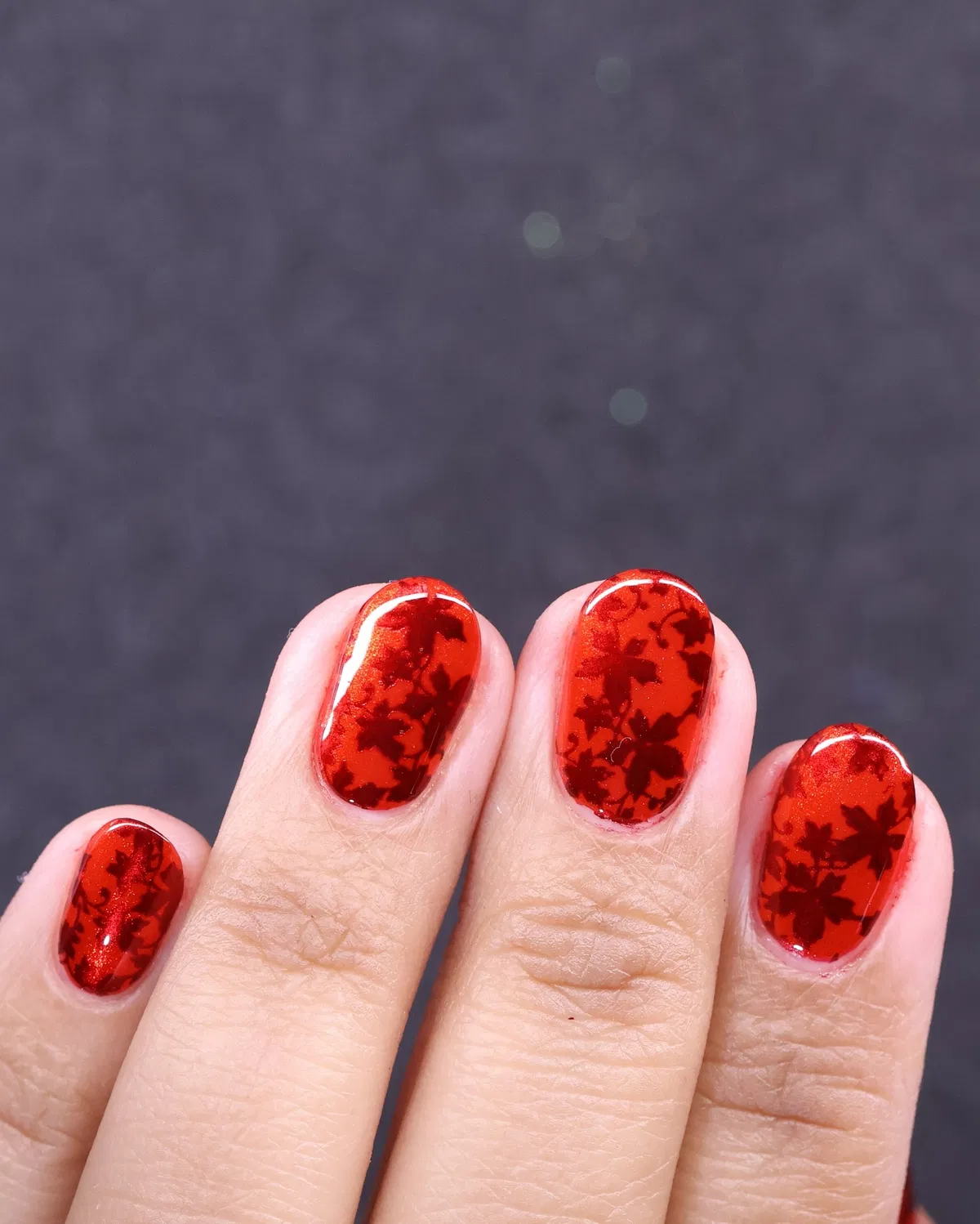 Red leaf silhouette pattern on glossy nails
