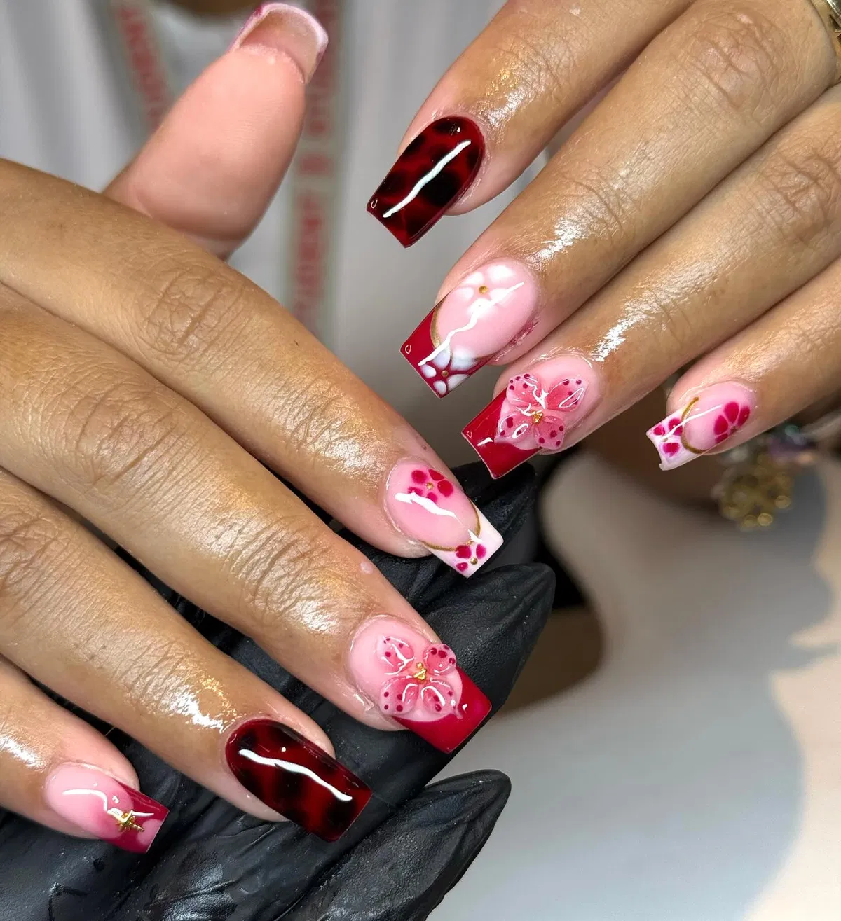 Pink nude and red tips with white swirls and 3D floral accents