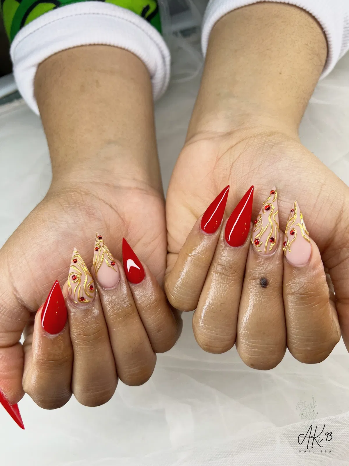 Solid red stilettos with gold linework and red rhinestones