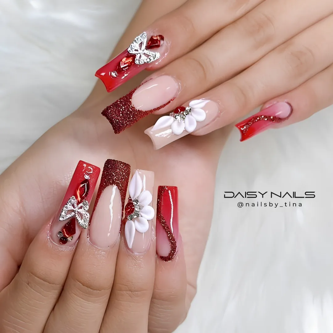 Nude-and-red coffin nails with bows, glitter, and 3D flowers