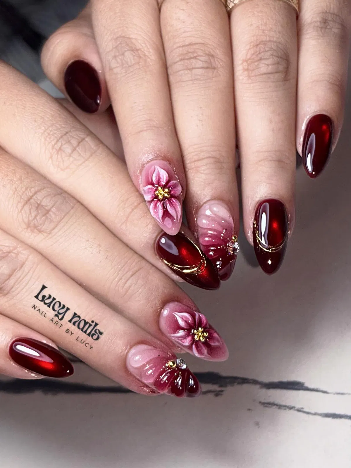 Deep burgundy almonds with pink 3D flowers and rhinestones