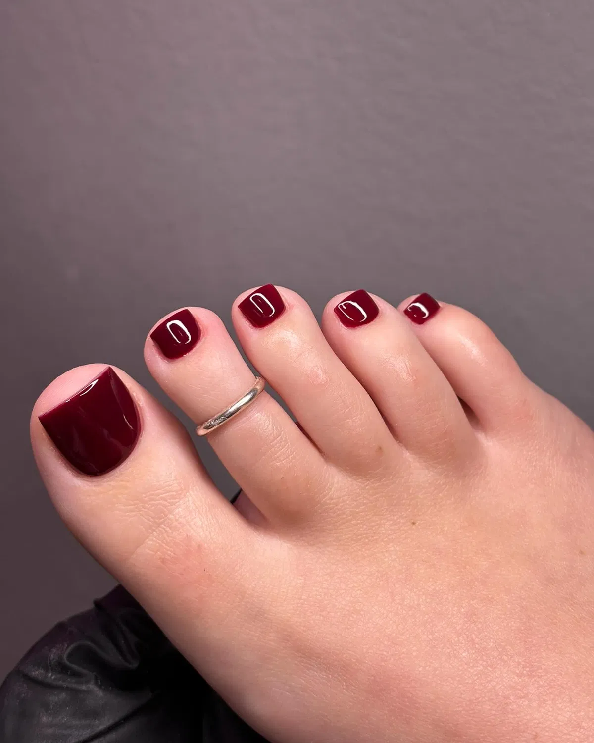 Minimal deep burgundy glossy pedicure with toe ring