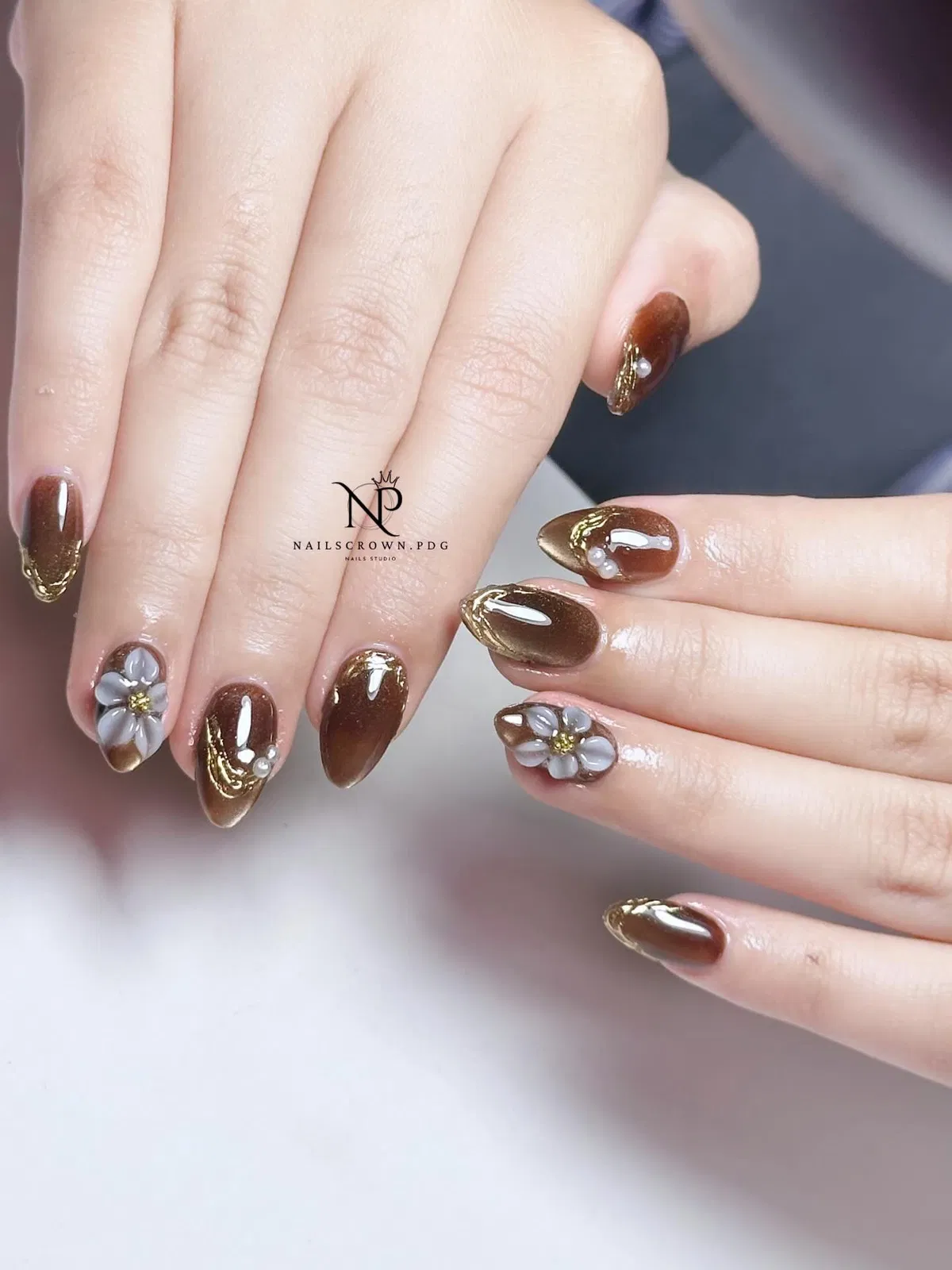 Brown Almond Nails with Gold Edges and 3D Floral Accents