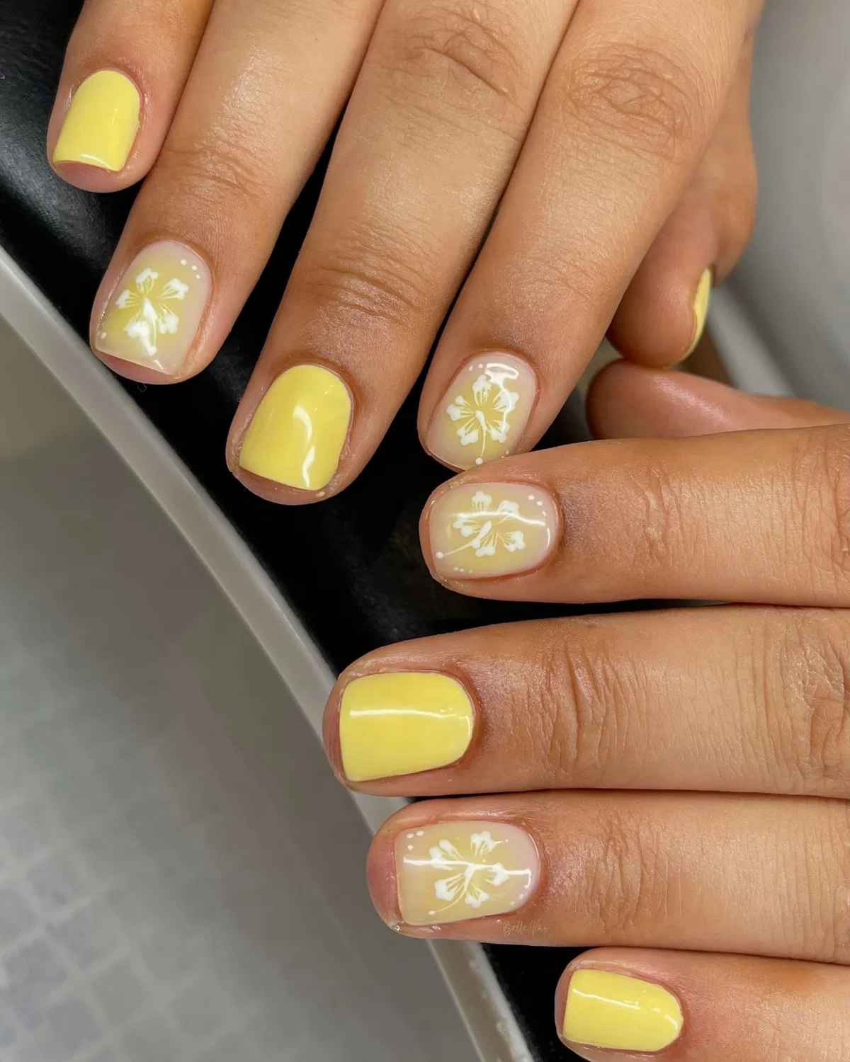 Soft yellow with white floral accent nails