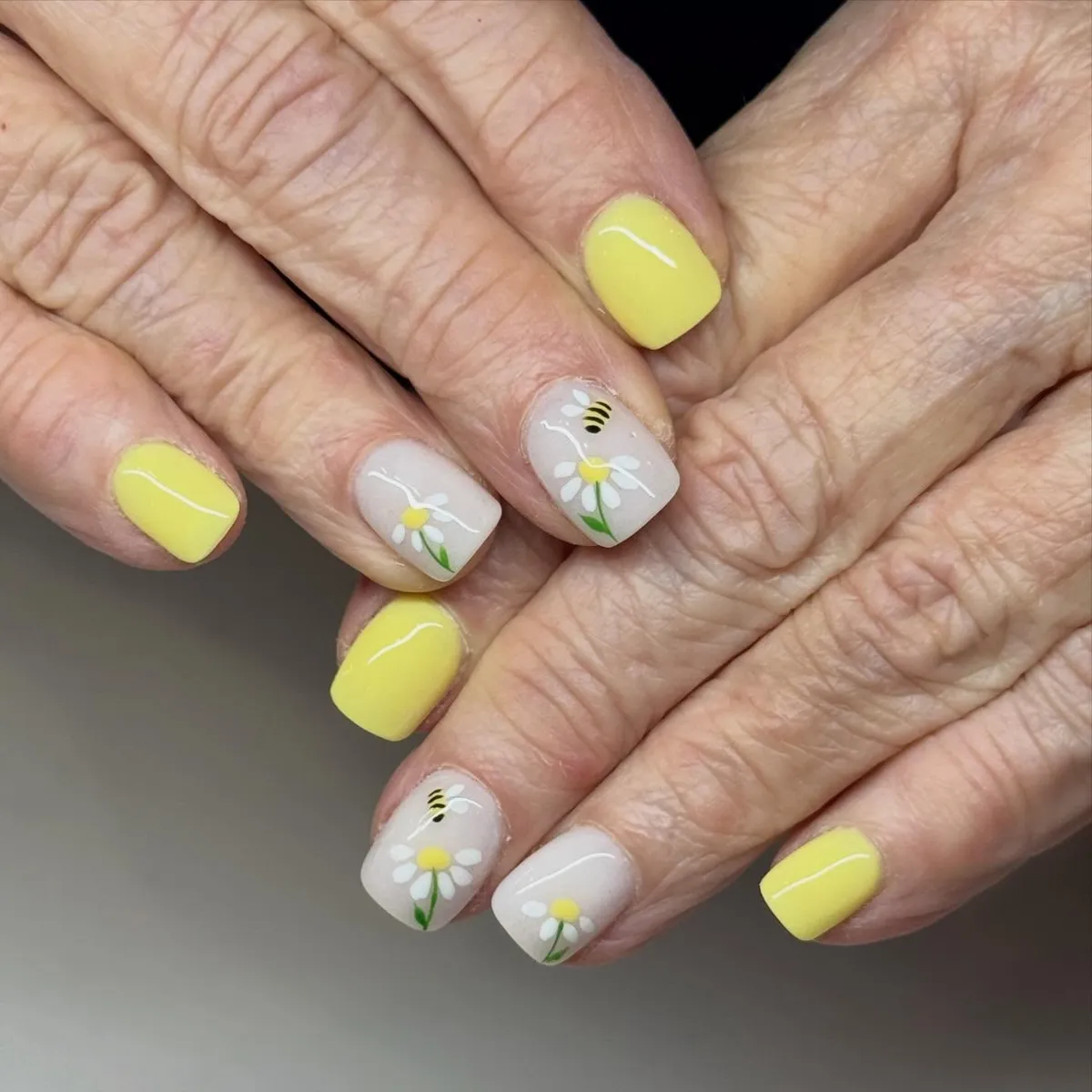 Pale yellow with daisy-and-bee accent nails