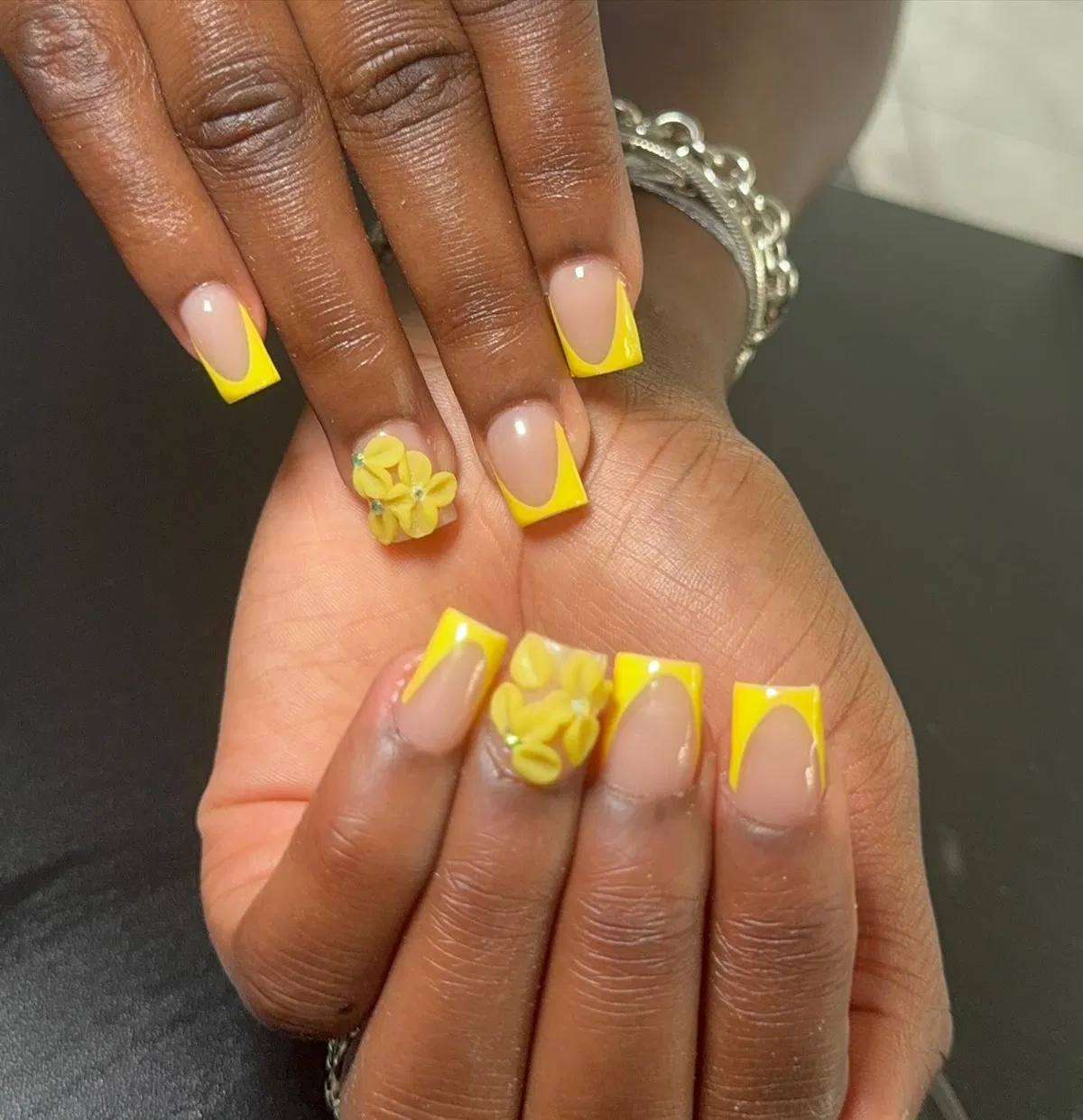 Nude base with bright yellow French tips and 3D flowers