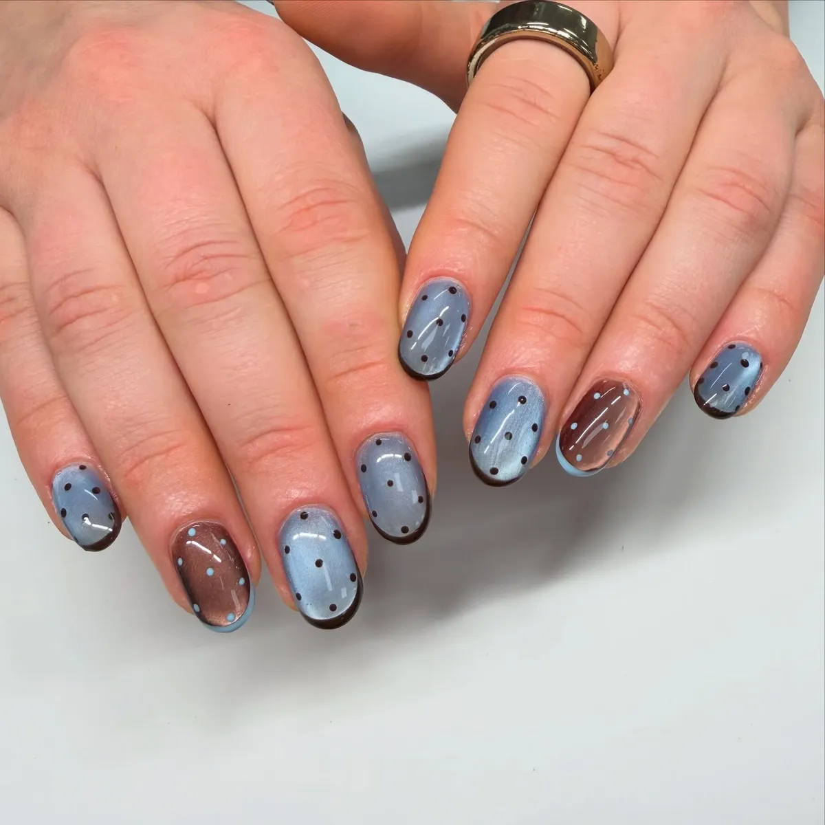 Light blue and brown dotted nails with outlined edges