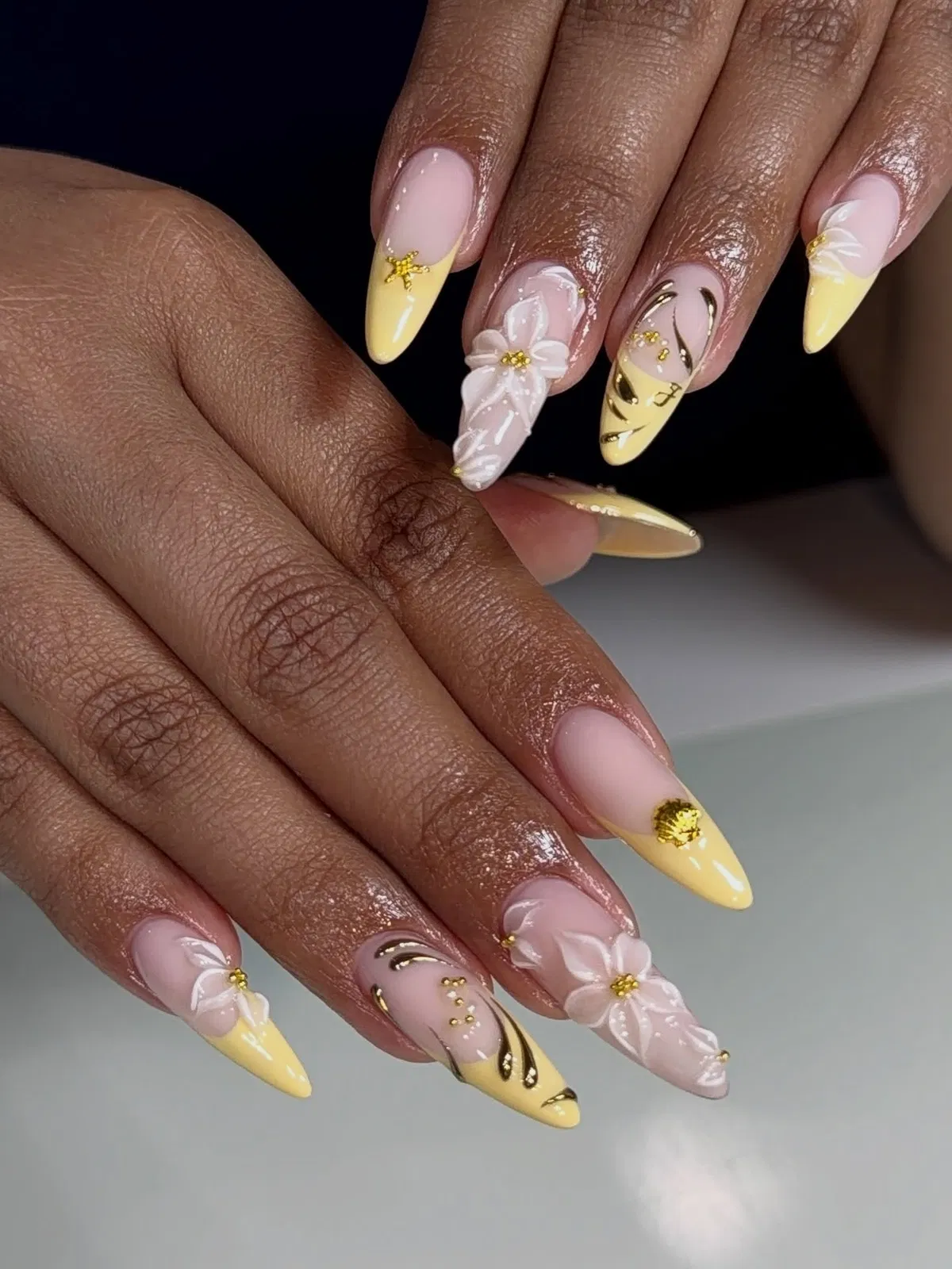 Yellow French tips with pearly shine and raised floral accents