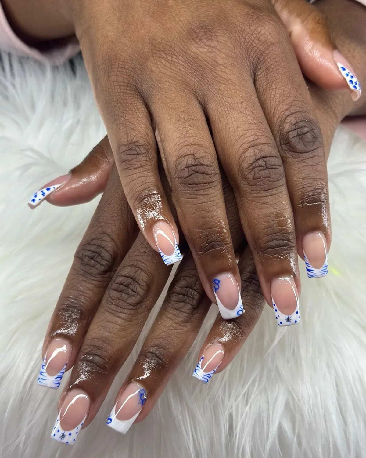 White French tips with blue linework and dotted accents