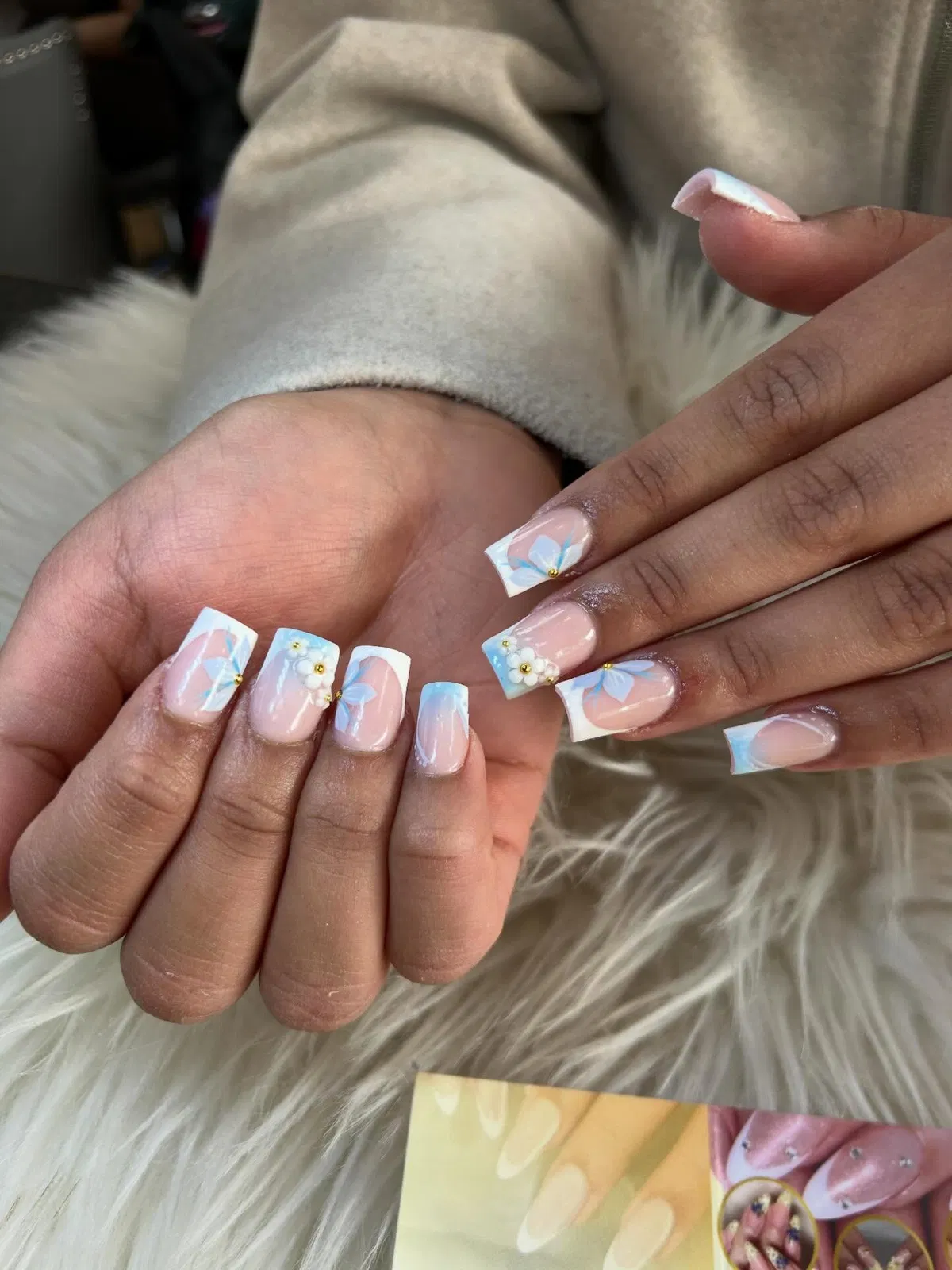 White French tips with light-blue gradients and floral accents