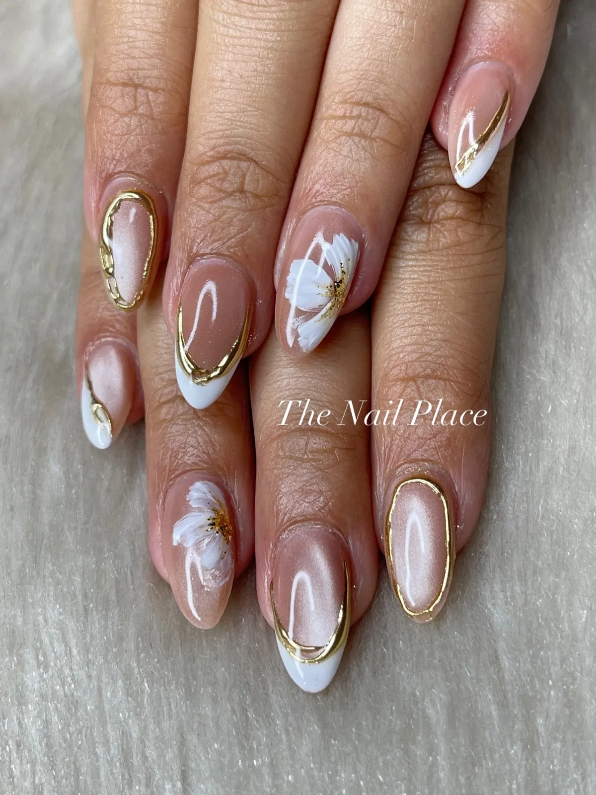 Gold-outlined French tips with white floral accents