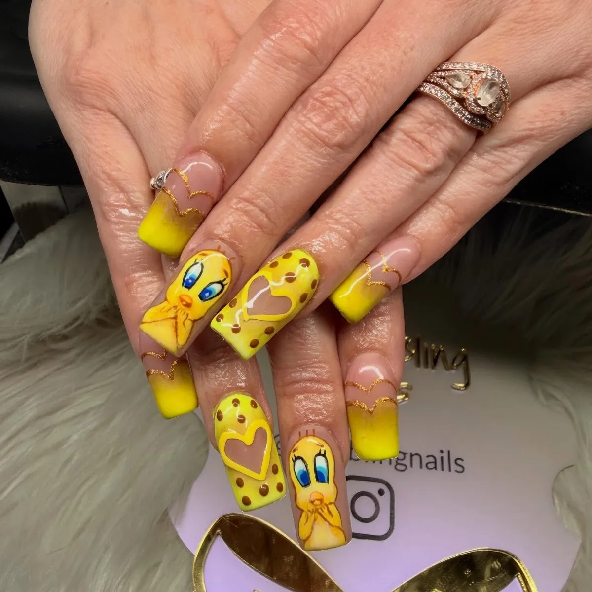 Yellow gradient nails with gold waves, hearts, and cartoon bird art