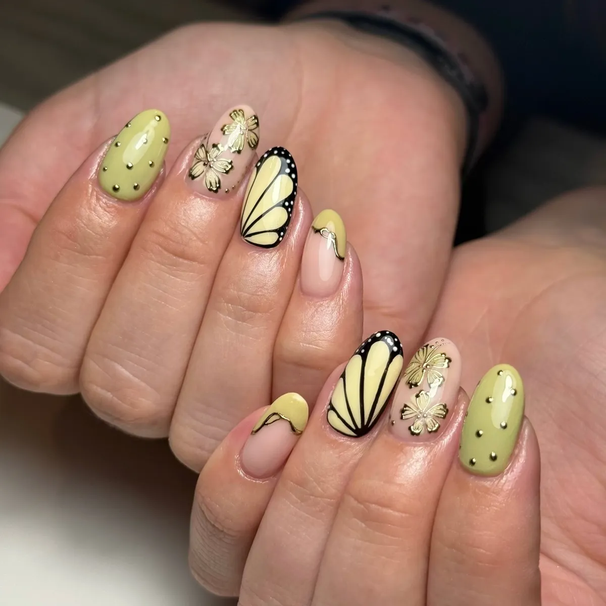 Muted yellow-green with butterfly-wing accents and gold studs