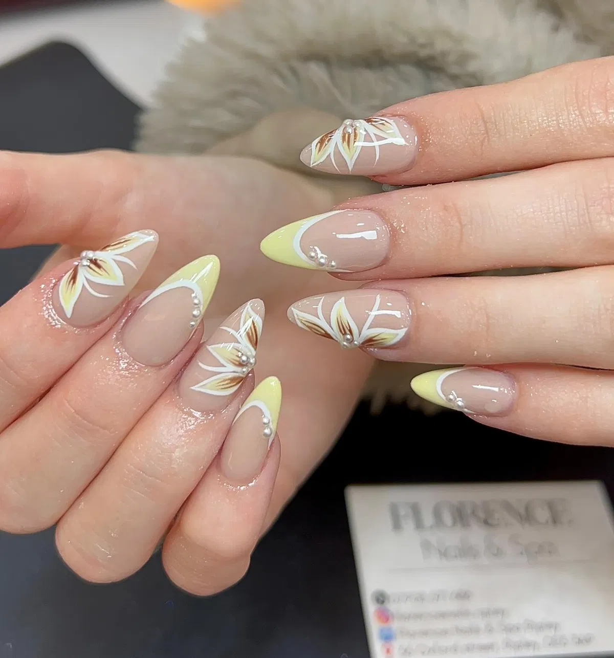 Pale yellow tips with white floral line art and pearls
