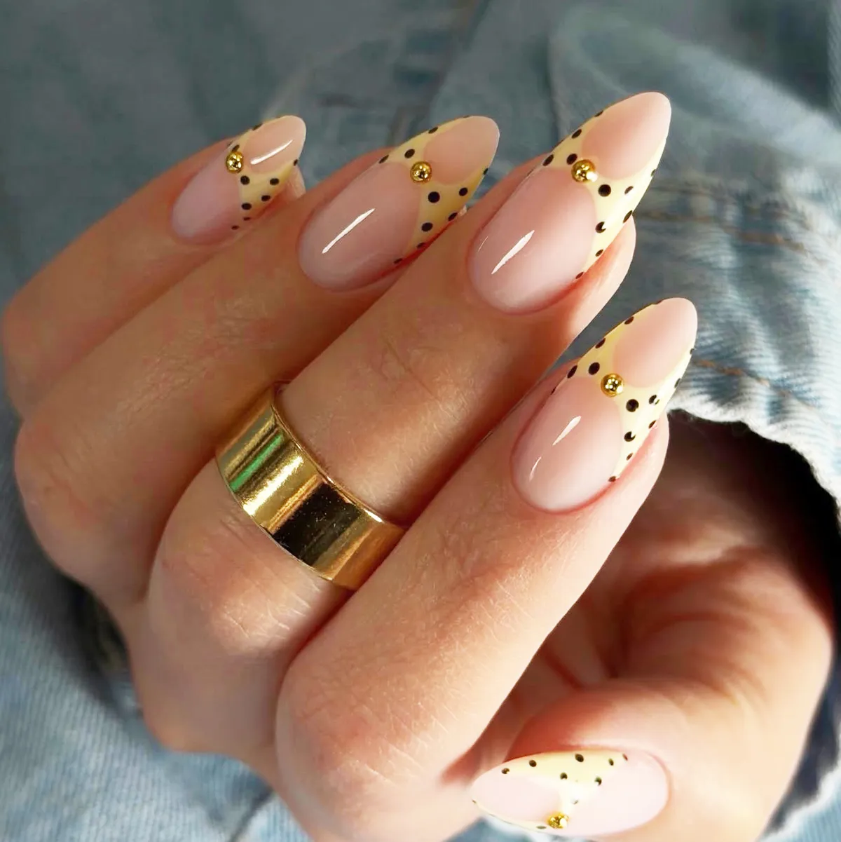 Pale yellow dotted French tips with gold bead accents