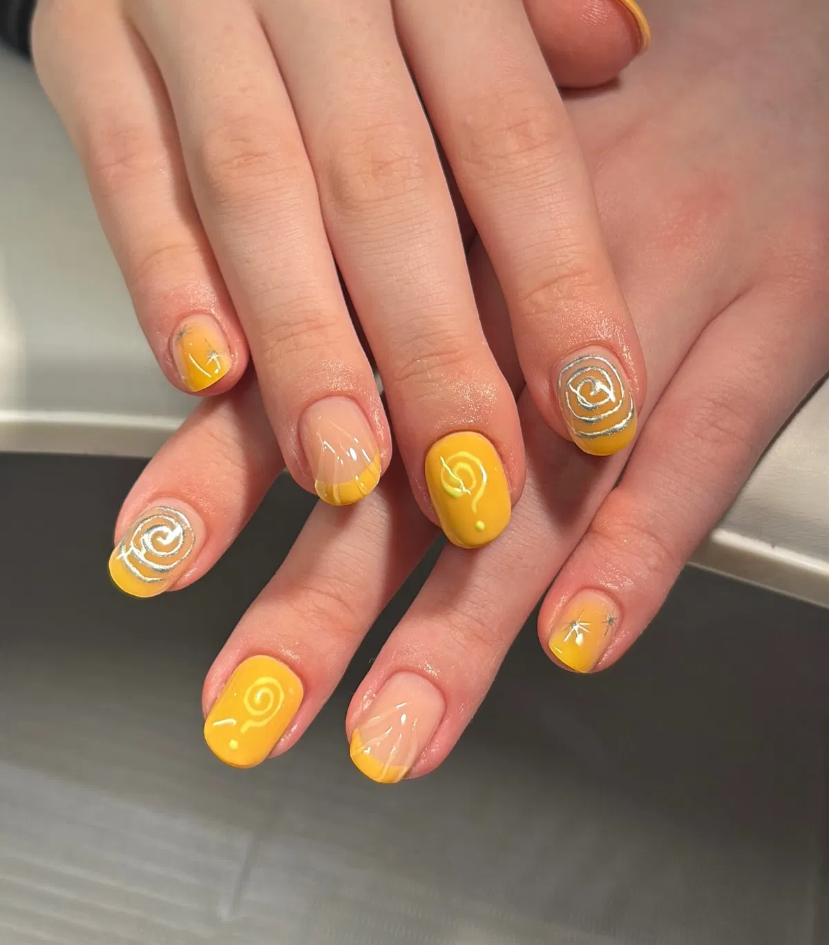 Bright yellow short nails with raised white swirls