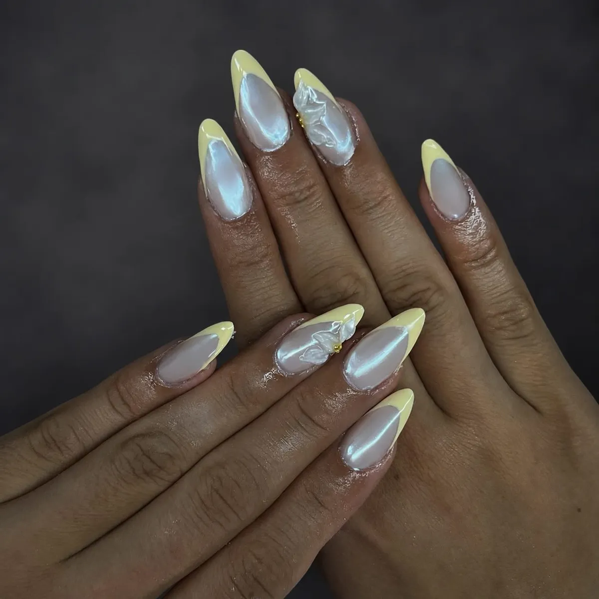 Pale yellow French tips with pearly sheen and 3D white accents