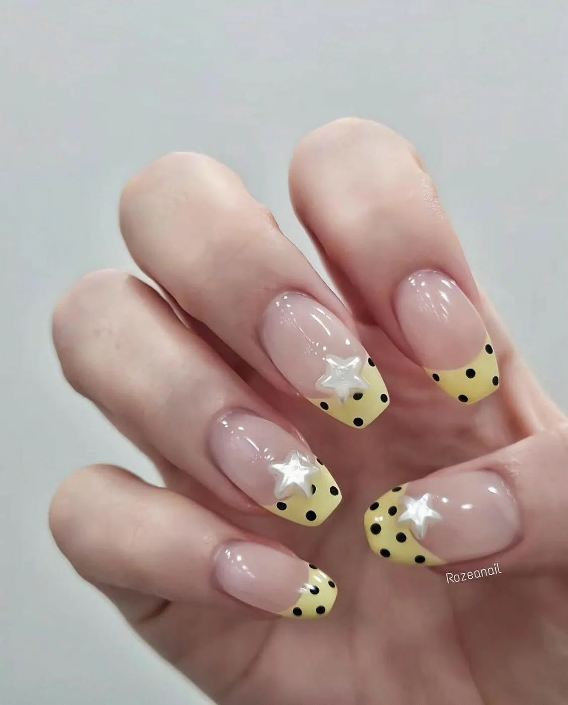 Polka-dot yellow French tips with white star embellishments