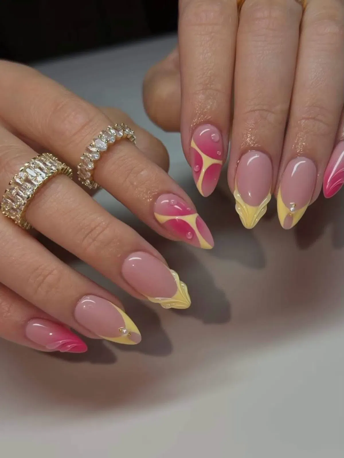 Abstract yellow French tips with pink accents and raised 3D tip details